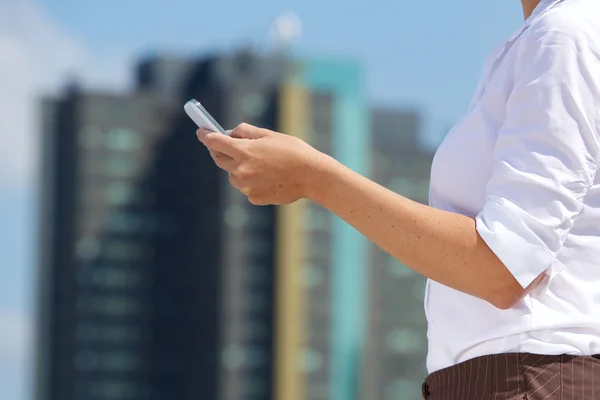 Podnikání žena drží mobil v městě — Stock fotografie