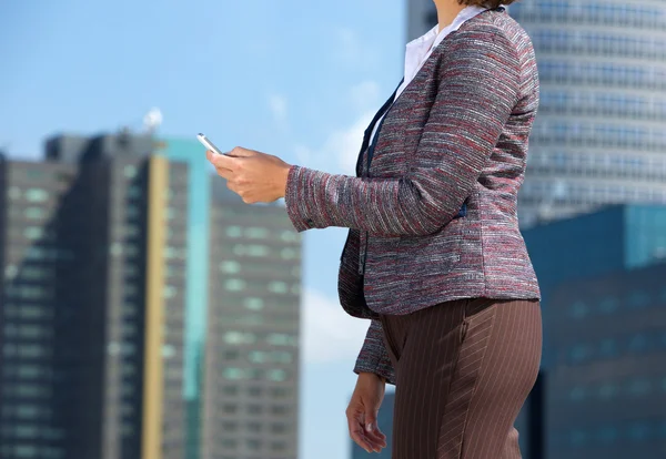 Kvinnan promenader i staden med mobiltelefon — Stockfoto