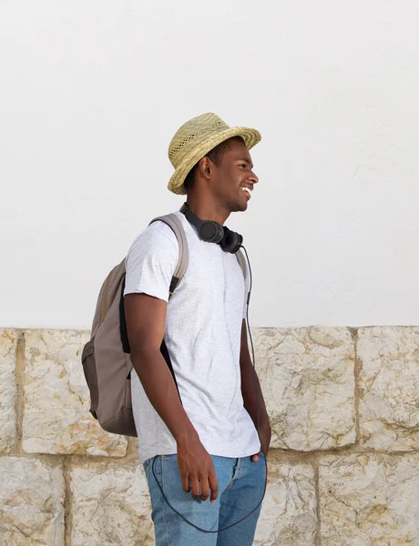 Joyeux jeune homme marchant avec sac et chapeau — Photo