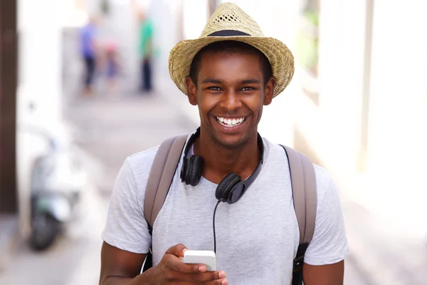 Feliz viajero caminando en la ciudad con teléfono móvil — Foto de Stock