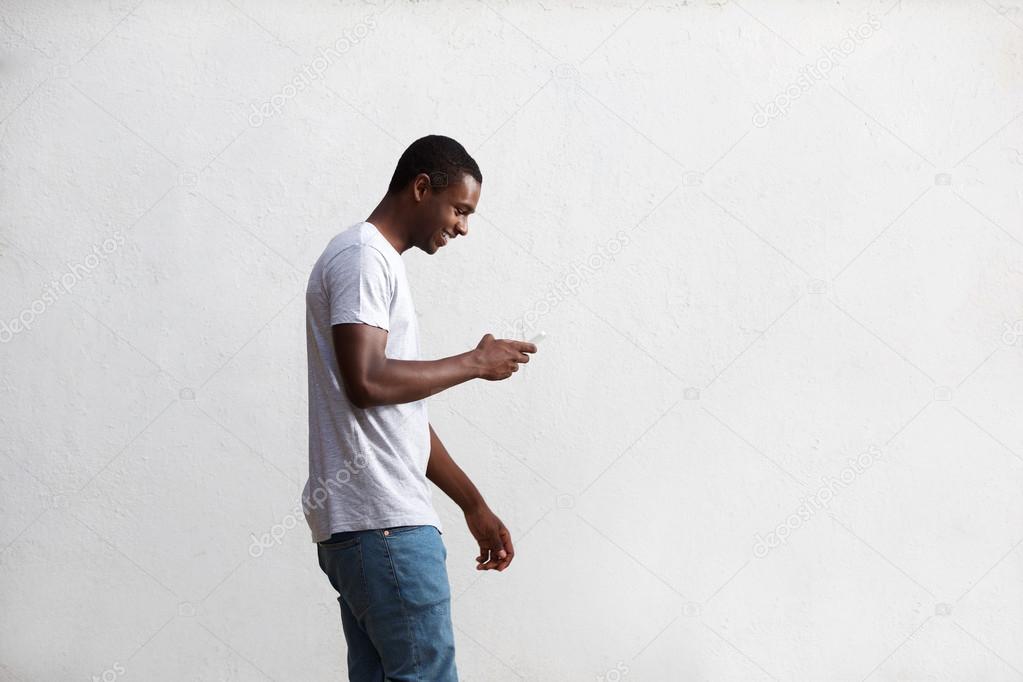 Happy guy walking and using mobile phone