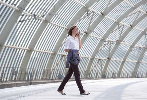 ビジネスの女性歩行と携帯電話で話しています。 — ストック写真