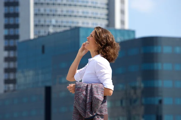 Zakenvrouw lopend en pratend op mobiele telefoon in de stad — Stockfoto