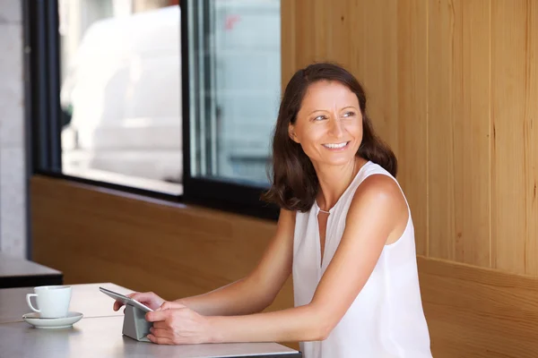 Lächelnde Frau sitzt mit Tablet im Restaurant — Stockfoto
