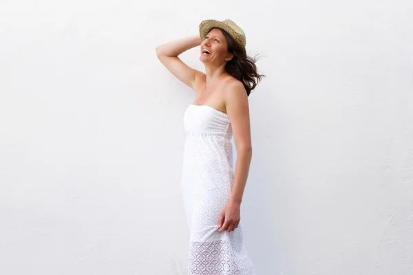 Cheerful woman in summer dress walking with hat — Stock Photo, Image