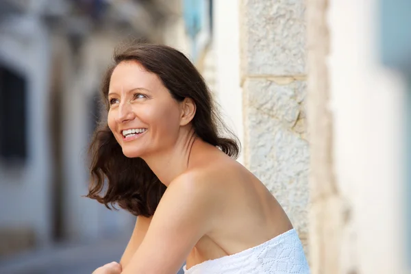 Smiling older woman sitting outside — Stock Photo, Image