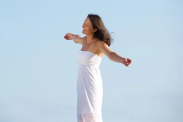 Carefree woman standing outside with arms spread open — Stock Photo, Image