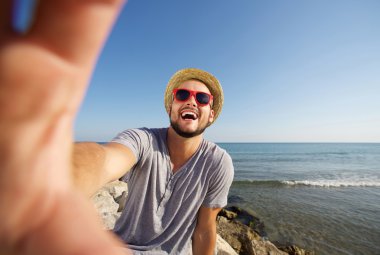 Adam tatilde plajda selfie alarak gülüyor