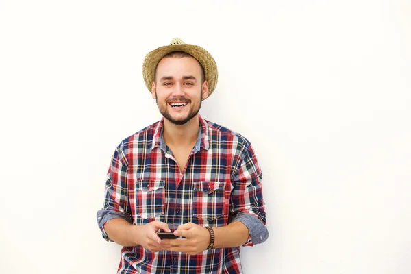 Junger Mann mit Hut lächelt mit Handy — Stockfoto