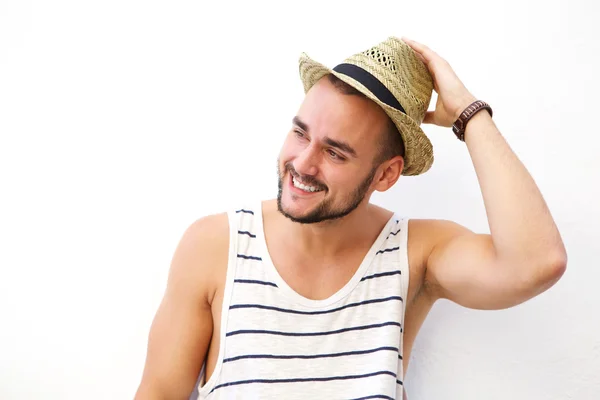 Glücklicher junger Mann mit Bart, der mit Hut lächelt — Stockfoto