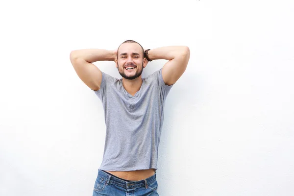 Heureux jeune homme souriant avec les mains derrière la tête — Photo