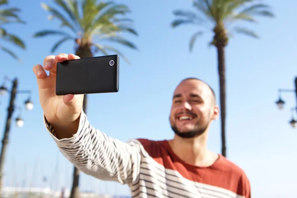 Jovem feliz tirando uma selfie com celular — Fotografia de Stock