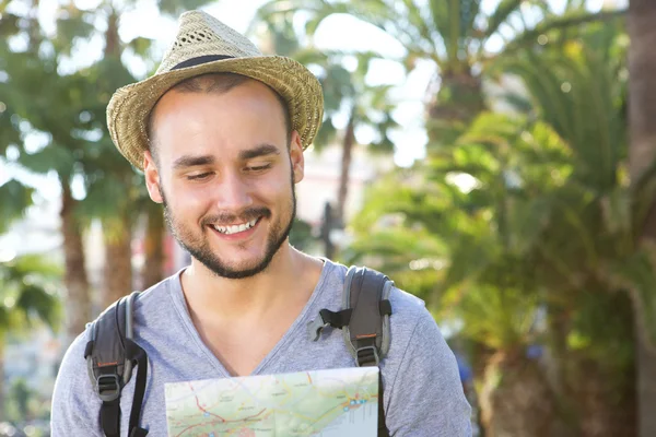 Sonriente joven viajero mirando el mapa — Foto de Stock