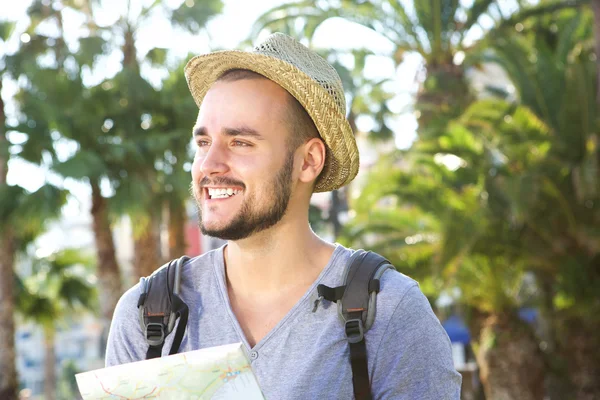 Glimlachend jonge reizende kerel kaart buiten bedrijf — Stockfoto