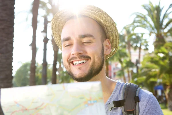 Hombre feliz leyendo mapa mientras está de vacaciones — Foto de Stock