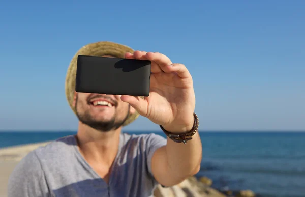 Sorridente uomo prendere selfie in spiaggia — Foto Stock
