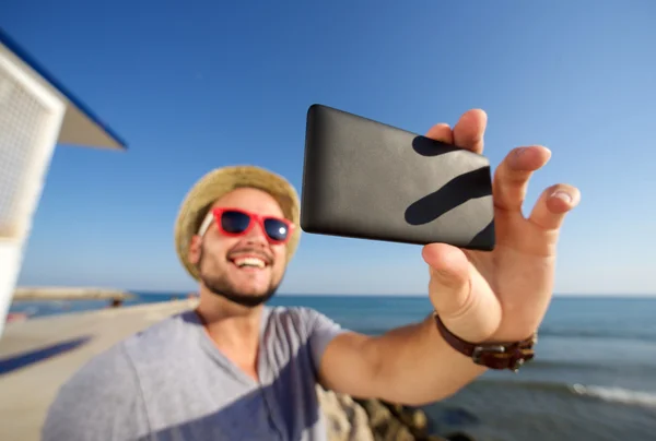 Jovem sorridente de férias na praia tirando selfie — Fotografia de Stock