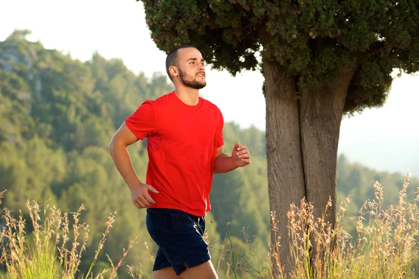 Jovem desportivo correndo ao ar livre — Fotografia de Stock