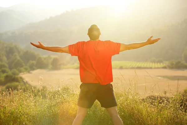 Man die in de natuur met uitgestrekte armen — Stockfoto