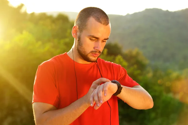 Sports man checking time on watch after workout