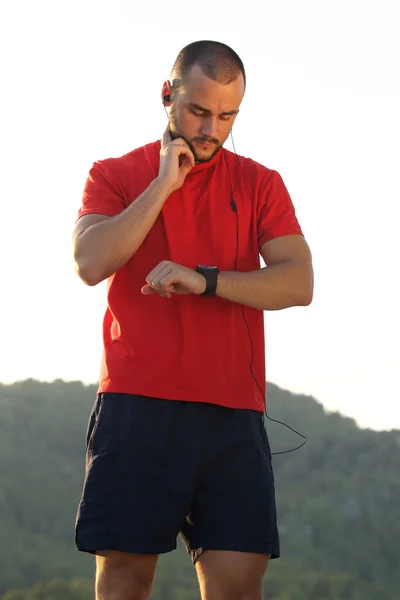 Young man keeping in shape and checking pulse — Stock Photo, Image