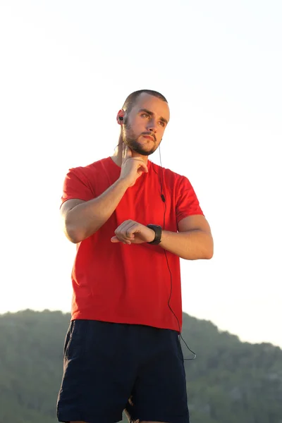 Sportmann überprüft Puls mit Uhr — Stockfoto