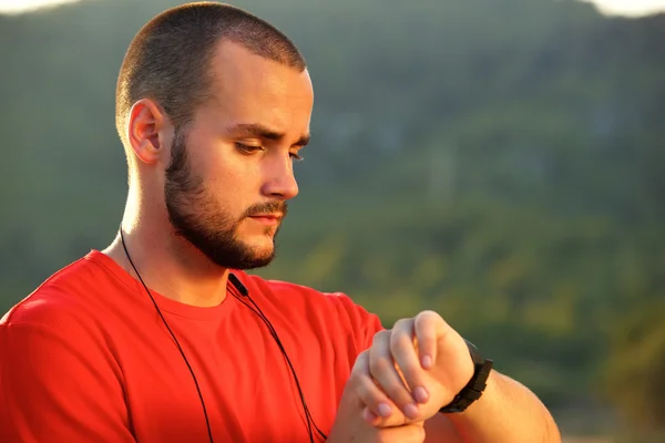 Athletic man standing outside checking watch — Stock Photo, Image