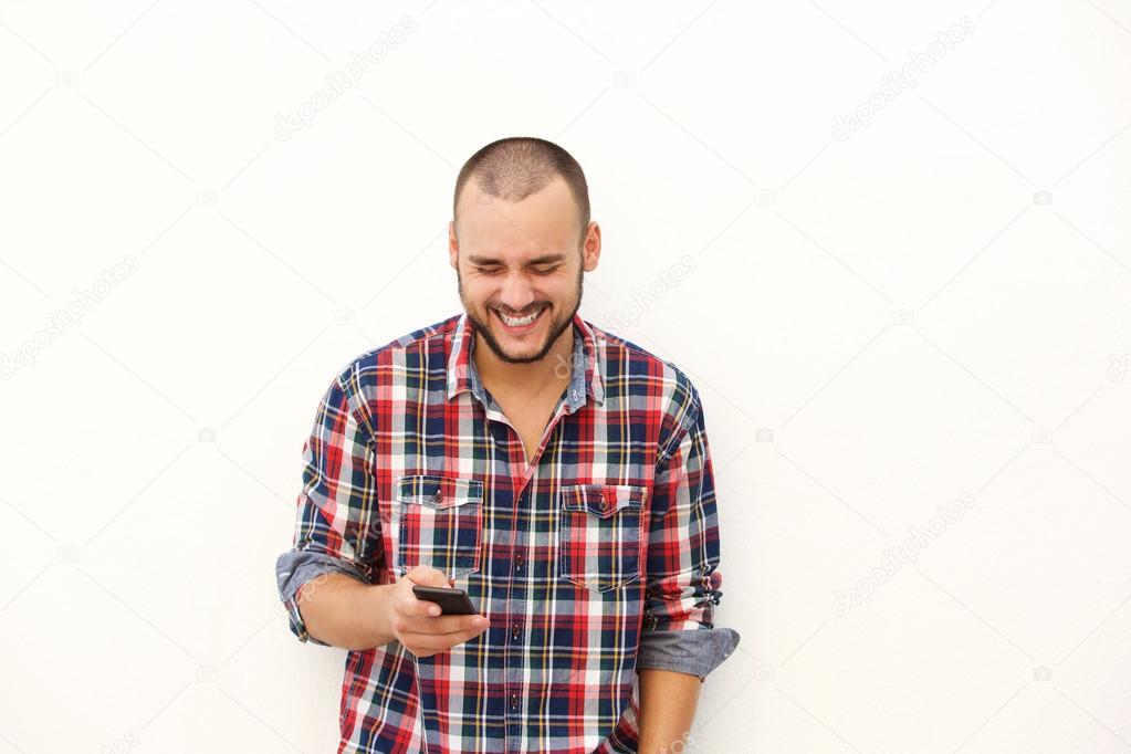 Man laughing after reading text on mobile phone