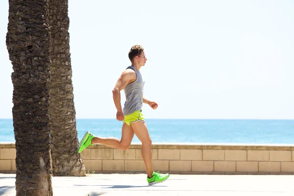 Hombre de fitness corriendo por el lado del mar —  Fotos de Stock