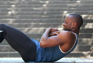 African american man sport training workout sit ups outside clipart