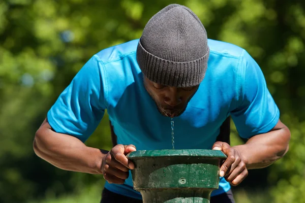 Διψασμένος αφρικανική αμερικανική άνθρωπος πόσιμο νερό — Φωτογραφία Αρχείου