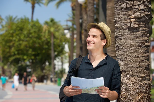 Turista sorridente com mapa e saco — Fotografia de Stock