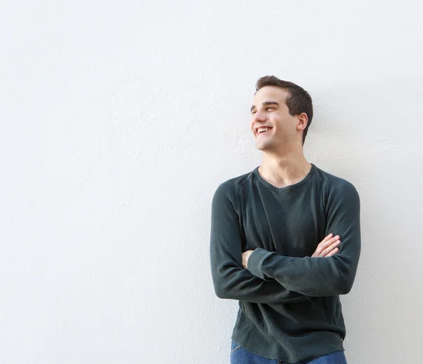 Young man standing against white background with arms crossed — Stock Photo, Image