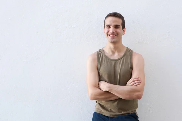 Smiling guy standing against white background with arms crossed — Stock Photo, Image