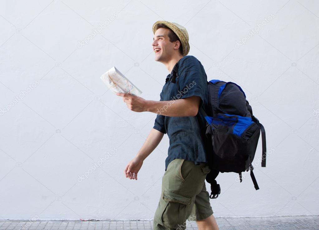 Smiling man going on vacation with bag and map