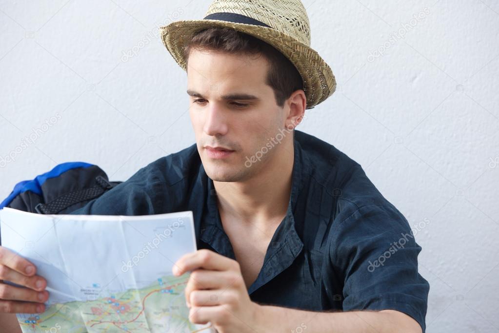 Young traveling man reading map 