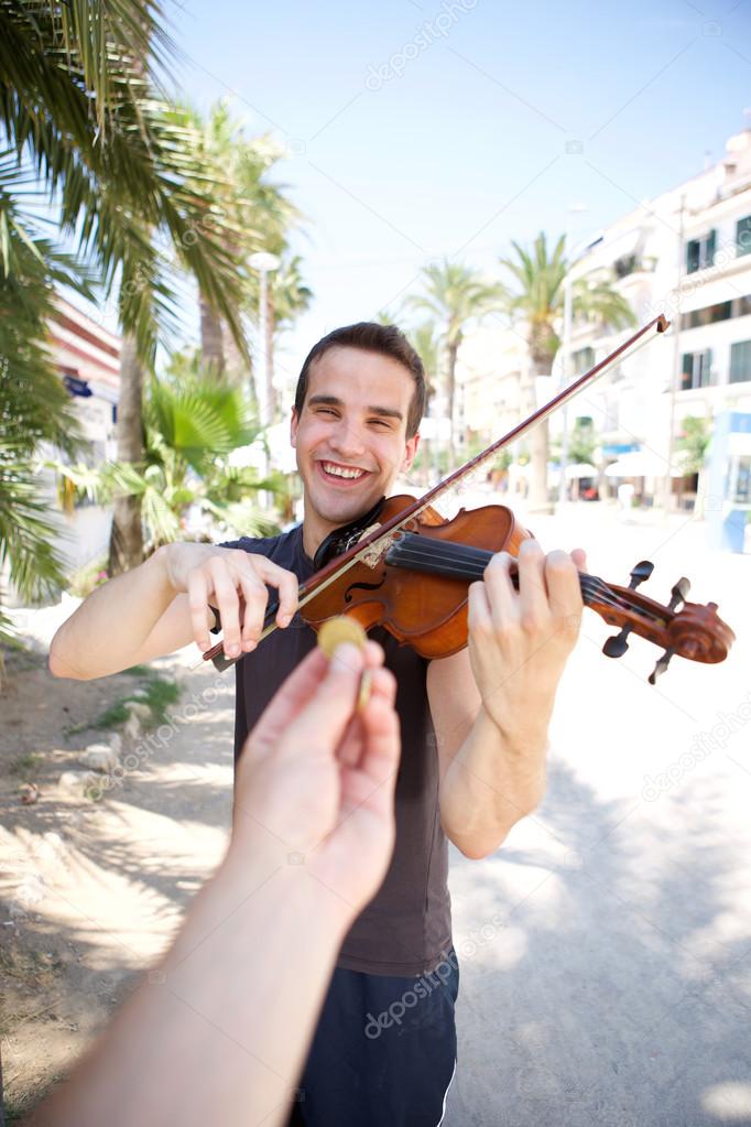 Busker playing violin outside for money