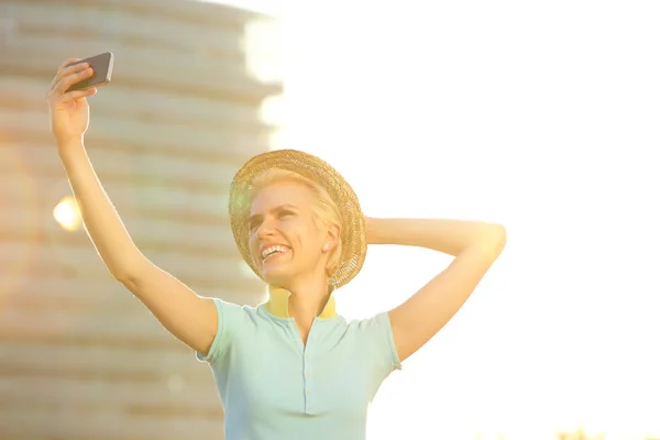 Souriant jeune femme de la mode avec chapeau prendre selfie — Photo