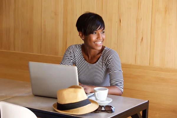 Jovem mulher negra sorrindo e usando laptop — Fotografia de Stock
