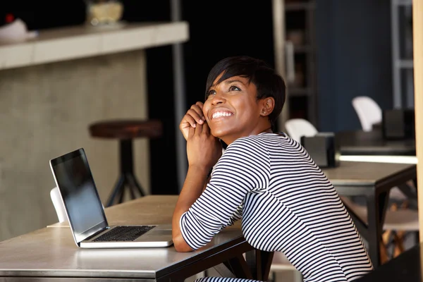 Jovem alegre sentada no café com laptop — Fotografia de Stock