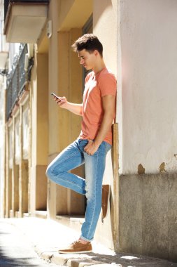 Çekici bir genç adam cep telefonu kısa mesaj okuma