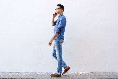 Yürüyüş ve cep telefonuyla konuşurken yakışıklı delikanlı