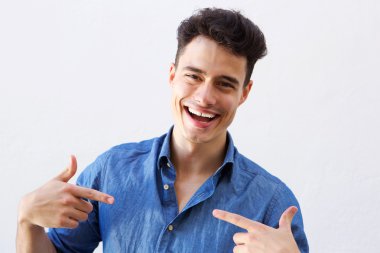 Yakışıklı adam gülümsüyor ve kendisine parmak noktasında