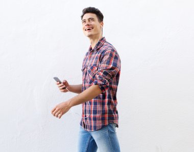 Yürüyüş ve cep telefonu müzik dinlerken neşeli adam