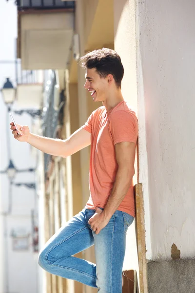 Knappe jongeman lezen SMS-bericht op mobiele telefoon — Stockfoto