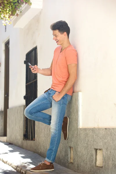 Glimlachende man die leest sms-bericht op mobiele telefoon — Stockfoto
