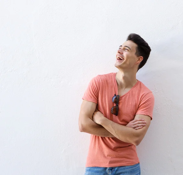 Självsäker ung man skrattar med armarna korsade — Stockfoto