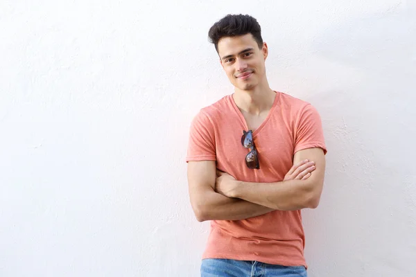 Confident young man smiling with arms crossed — Stock Photo, Image