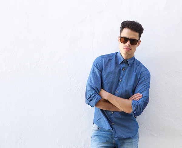 Joven confiado posando con gafas de sol — Foto de Stock