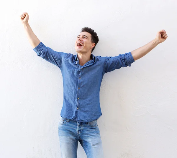 Glad ung man med upphöjda armar firar — Stockfoto